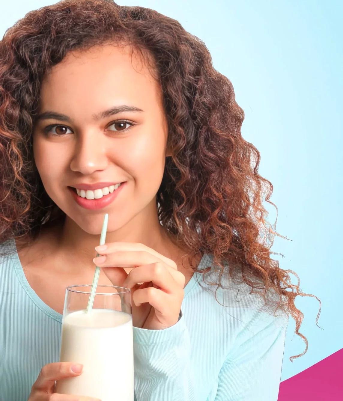A woman drinking a glass of milk through a straw